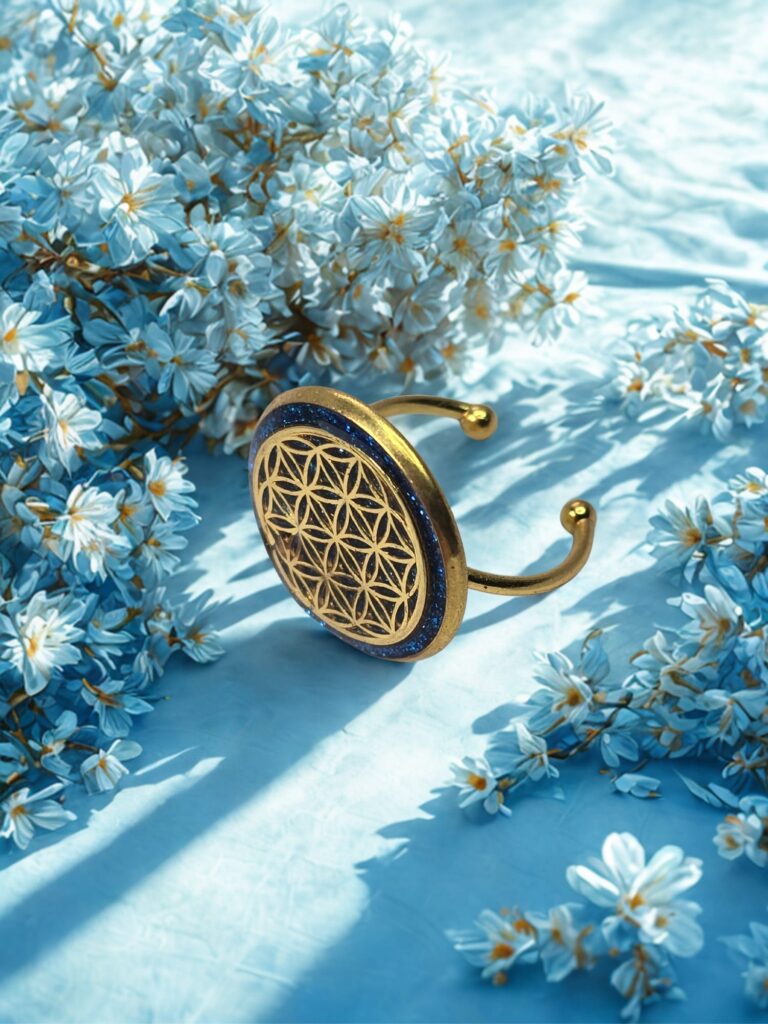 Bague fleur de vie dorée Saphir d’or fond bleu nuit de profil Jewels Spirit sur un lit de fleurs